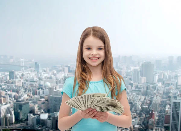 Leende liten flicka med dollar i kontanter — Stockfoto