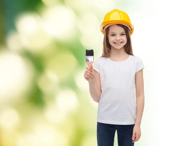 Petite fille souriante dans le casque avec rouleau de peinture — Photo