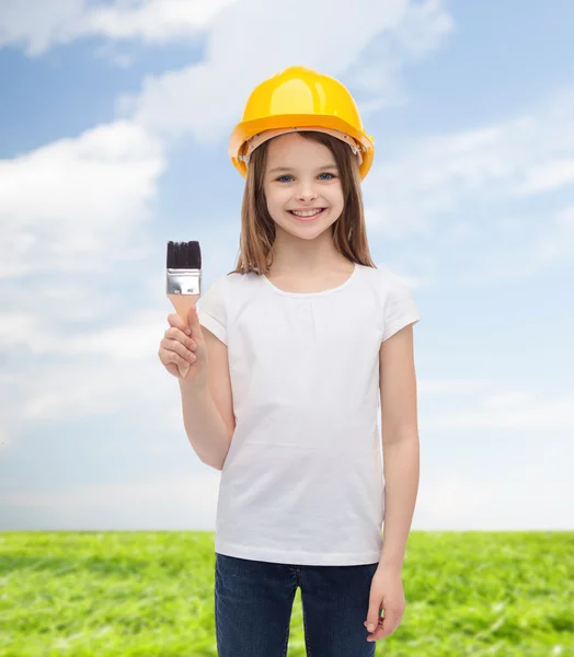 Niña sonriente en casco con rodillo de pintura — Foto de Stock