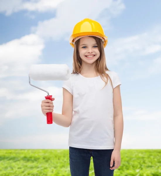 Niña sonriente en casco con rodillo de pintura —  Fotos de Stock