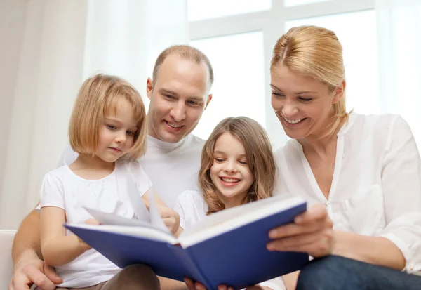 微笑的家庭和两个小女孩拿着本书 — 图库照片