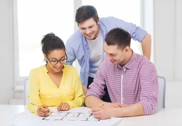 Tres arquitectos sonrientes trabajando en la oficina — Foto de Stock