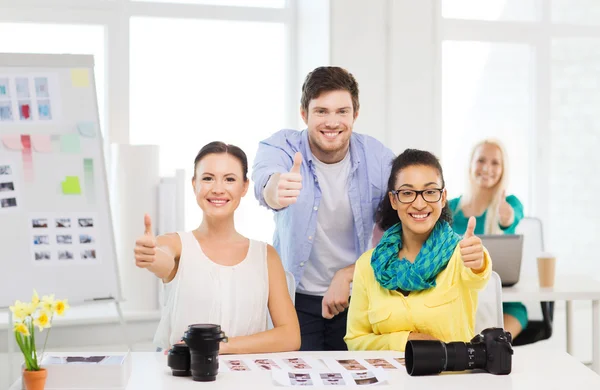 Equipe sorridente com fotocâmera no escritório — Fotografia de Stock