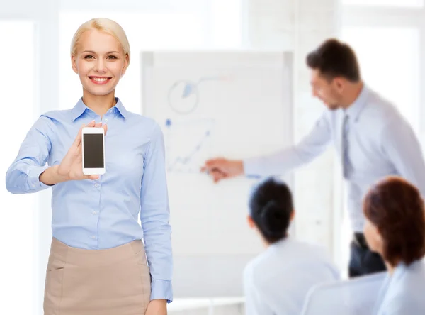 Mujer de negocios sonriente con pantalla en blanco para teléfonos inteligentes —  Fotos de Stock