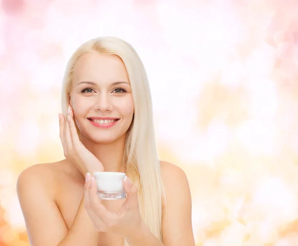 Mulher aplicando creme na pele — Fotografia de Stock