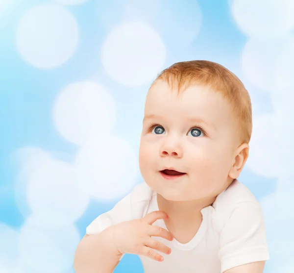 Sonriente bebé acostado en el suelo y mirando hacia arriba — Foto de Stock