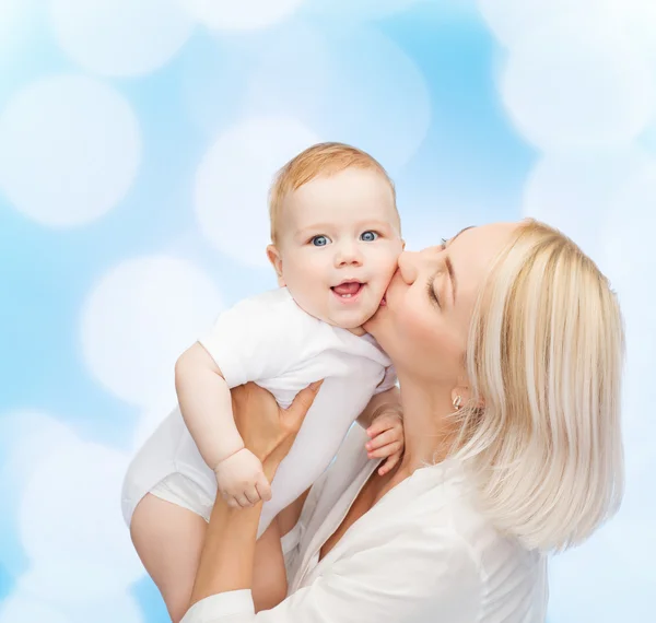 Mãe feliz beijando bebê sorridente — Fotografia de Stock