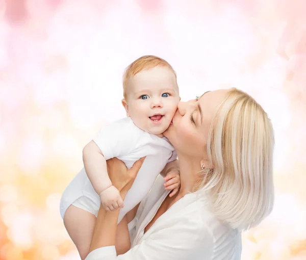 Happy matka líbání usmívající se dítě — Stock fotografie