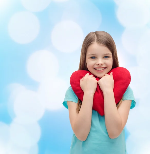 Улыбающаяся маленькая девочка с красным сердцем — стоковое фото