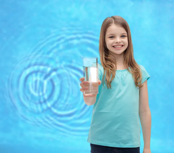 Улыбающаяся маленькая девочка, дающая стакан воды — стоковое фото