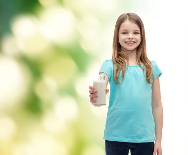 Улыбающаяся маленькая девочка, дающая стакан молока — стоковое фото