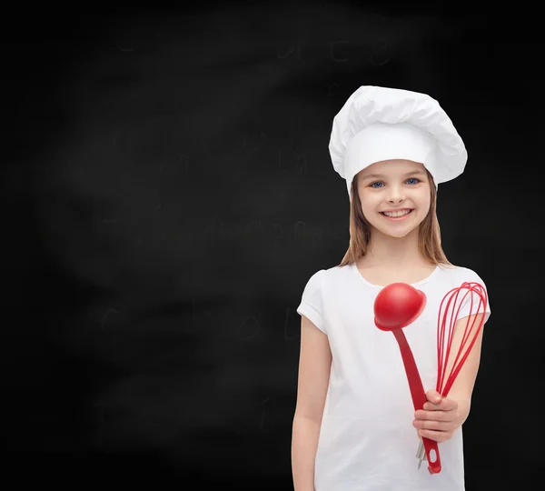 Leende flicka i cook mössa med slev och visp — Stockfoto