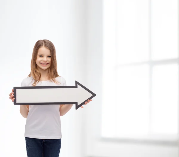 Menina sorrindo com seta em branco apontando para a direita — Fotografia de Stock