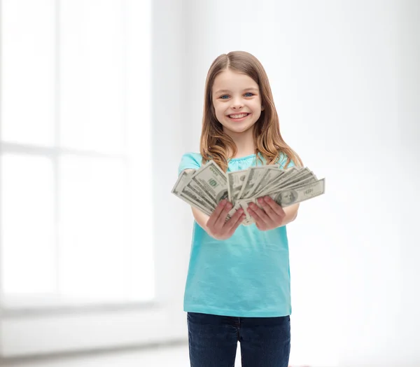 Sorrindo menina dando dinheiro em dinheiro dólar — Fotografia de Stock