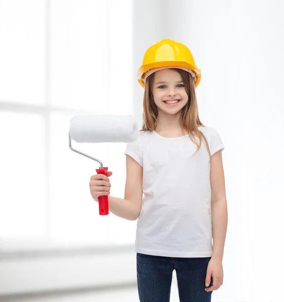 Niña sonriente en casco con rodillo de pintura —  Fotos de Stock