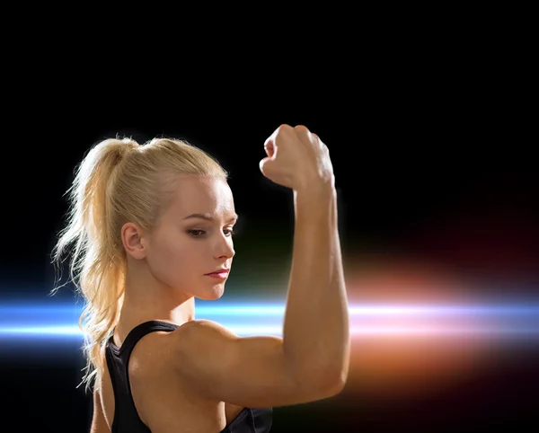 Primer plano de la mujer atlética flexionando sus bíceps — Foto de Stock