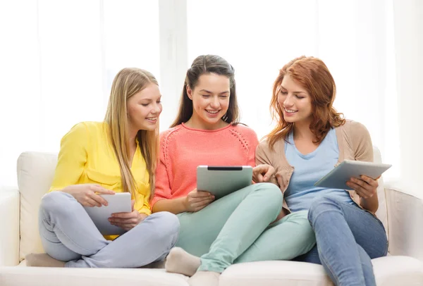 Três meninas adolescentes sorridentes com tablet pc em casa — Fotografia de Stock