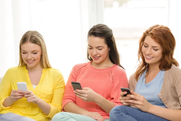 Meninas adolescentes sorridentes com smartphones em casa — Fotografia de Stock