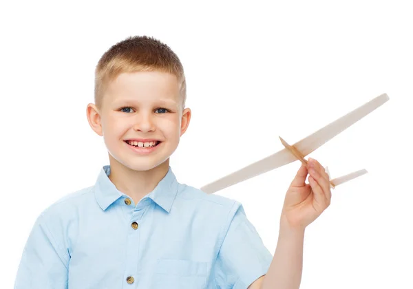 Lächelnder kleiner Junge mit einem hölzernen Flugzeugmodell — Stockfoto