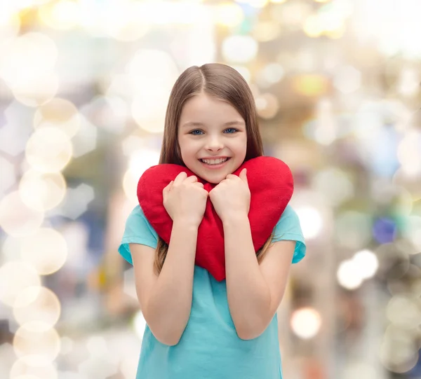 Усміхнена маленька дівчинка з червоним серцем — стокове фото