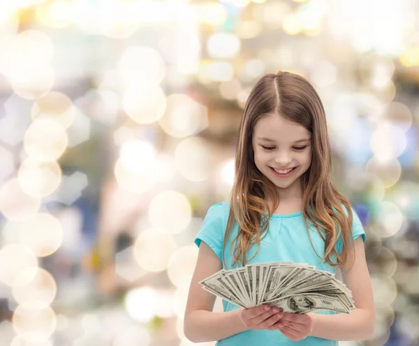 Sorridente bambina guardando denaro contante dollaro — Foto Stock