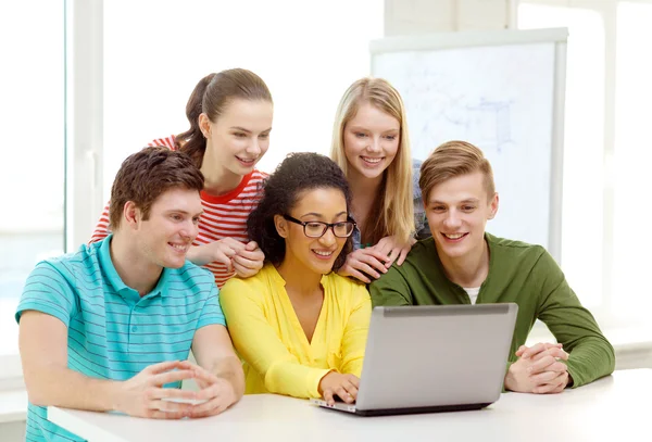 Estudantes sorrindo olhando para laptop na escola — Fotografia de Stock