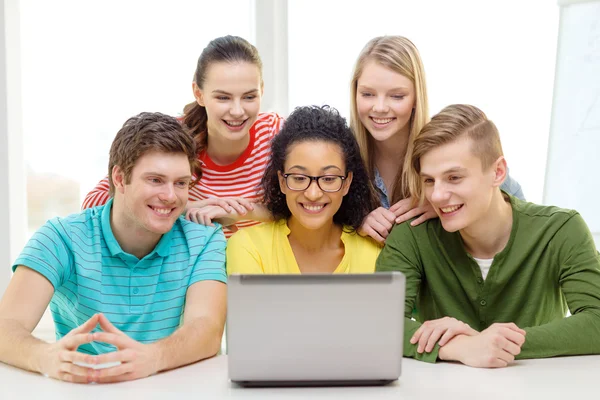 Estudantes sorrindo olhando para laptop na escola — Fotografia de Stock