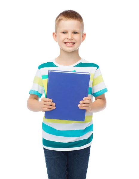 Sorridente piccolo studente ragazzo con libro blu — Foto Stock