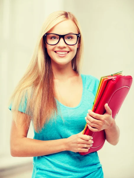 Улыбающийся студент с папками — стоковое фото