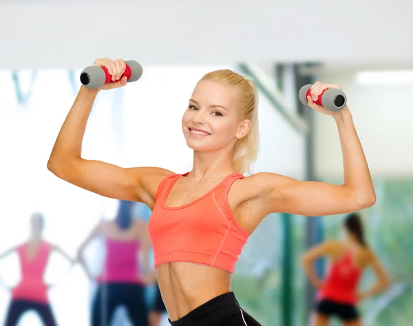 Sonriente hermosa mujer deportiva con mancuernas — Foto de Stock