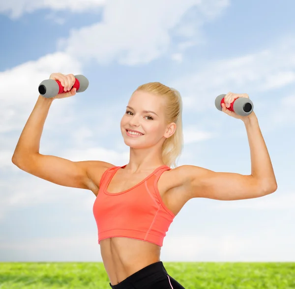 Sonriente hermosa mujer deportiva con mancuernas —  Fotos de Stock