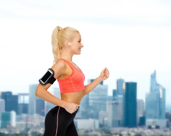 Mujer deportiva corriendo con smartphone y auriculares — Foto de Stock