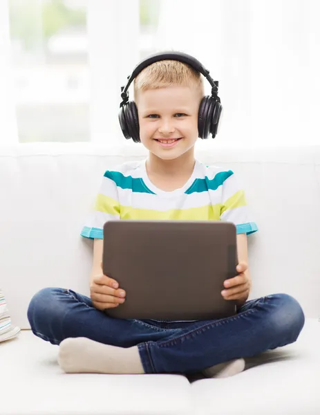 Petit garçon avec tablette PC et écouteurs à la maison — Photo