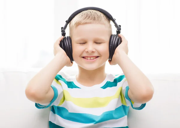 Bambino sorridente con le cuffie a casa — Foto Stock