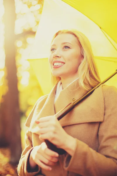 Жінка з жовтою парасолькою в осінньому парку — стокове фото