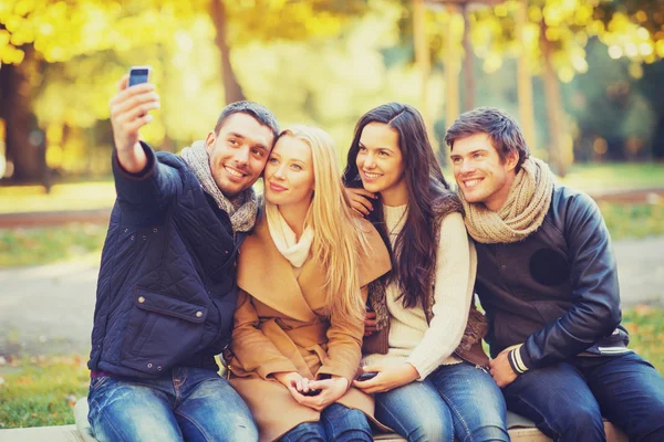 Grupo de amigos con cámara fotográfica en el parque de otoño — Foto de Stock