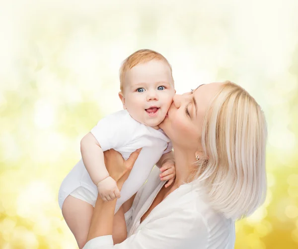 Mãe feliz beijando bebê sorridente — Fotografia de Stock