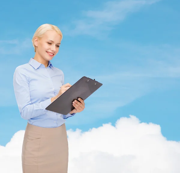 Smiling businesswoman with clipboard and pen — Stock Photo, Image