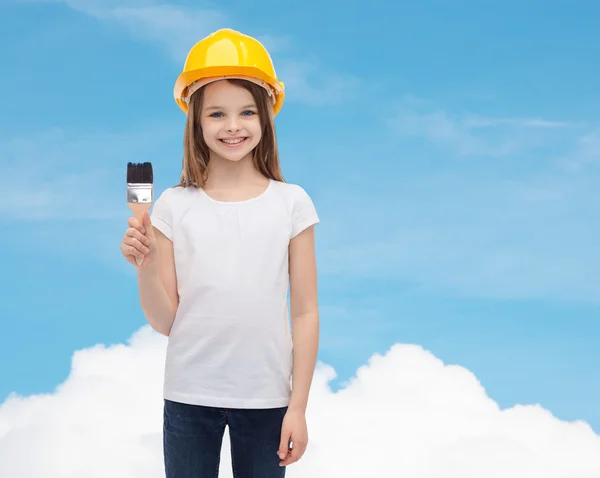 Niña sonriente en casco con rodillo de pintura —  Fotos de Stock