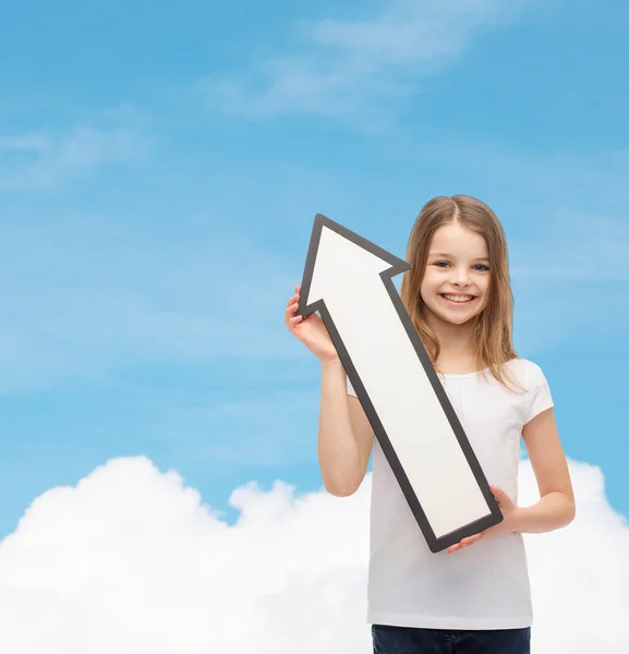 Petite fille souriante avec flèche vide pointant vers le haut — Photo