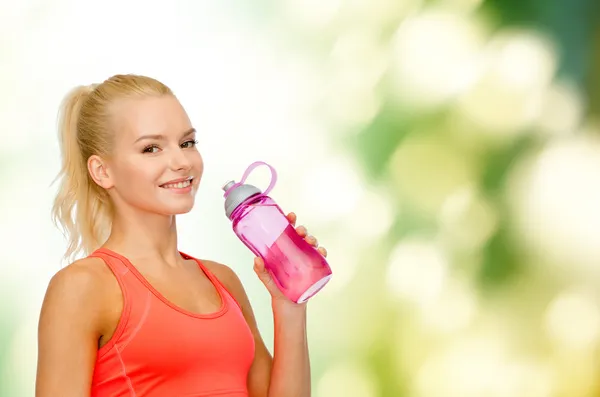 Lachende sportieve vrouw met water fles — Stockfoto