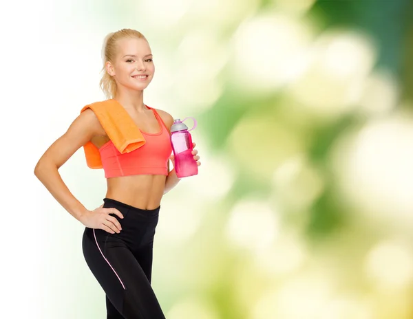 Mujer deportiva sonriente con botella de agua y toalla —  Fotos de Stock
