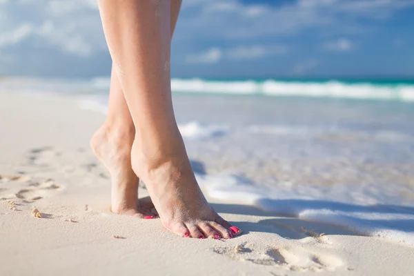 Primer plano de piernas de mujer en la orilla del mar — Foto de Stock
