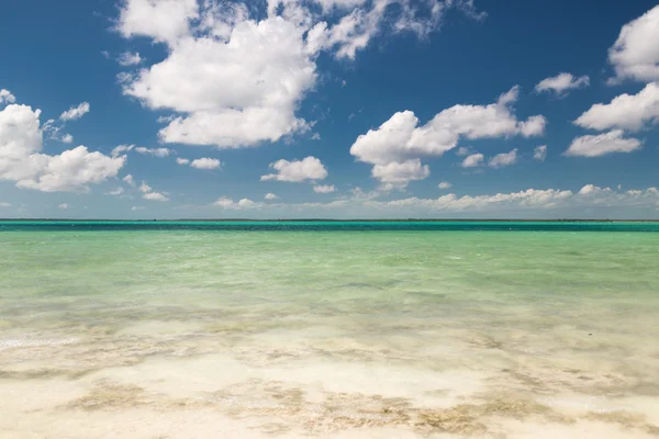 Mer ou océan bleu, sable blanc et ciel nuageux — Photo