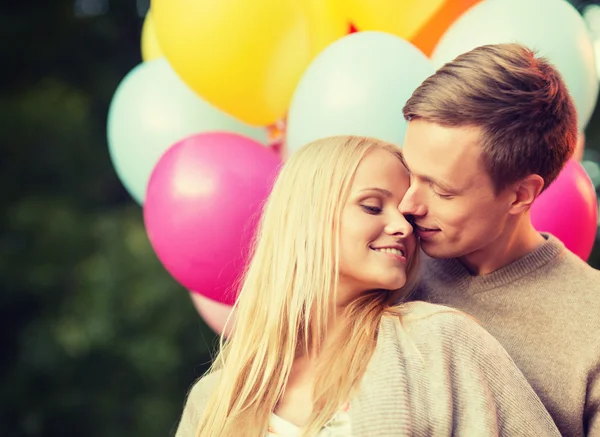 Coppia con palloncini colorati che si baciano nel parco — Foto Stock