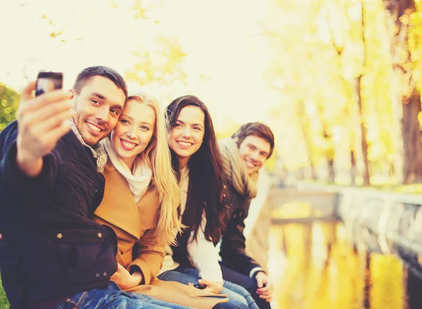 Grupo de amigos tomando selfie no parque de outono — Fotografia de Stock