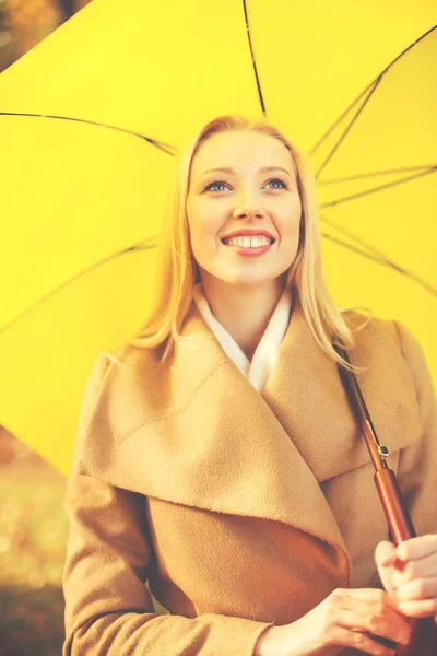 Woman with yellow umbrella in the autumn park — Stock Photo, Image