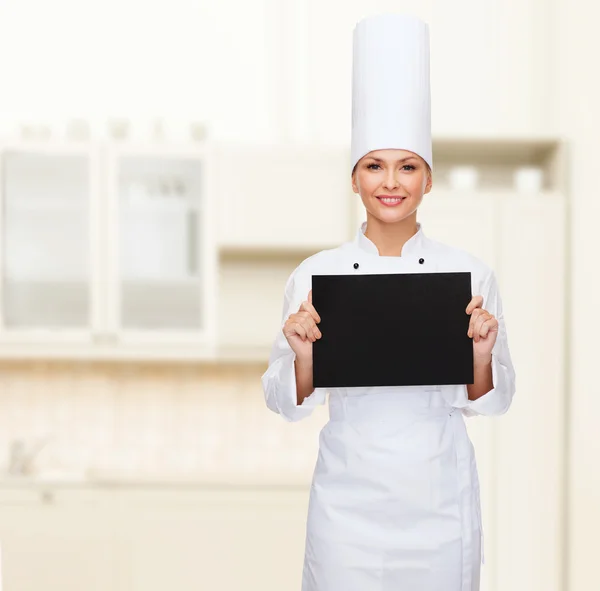 Lachende vrouwelijke chef-kok met zwarte blanco papier — Stockfoto