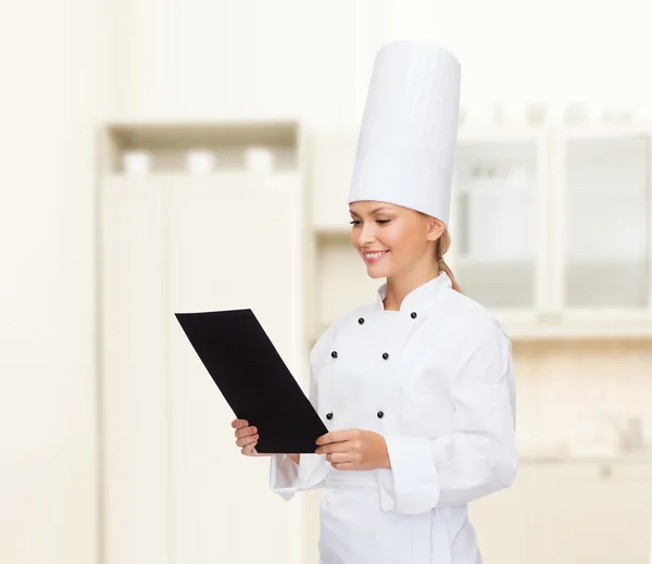 Chef feminino sorridente com papel em branco preto — Fotografia de Stock