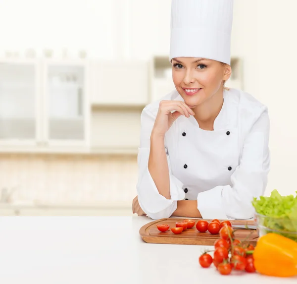 Chef feminino sorridente com legumes — Fotografia de Stock